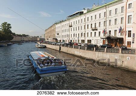 Stock Image - A Boat Carrying Passengers Travels Down Moyka River; St. Petersburg Russia. Fotosearch