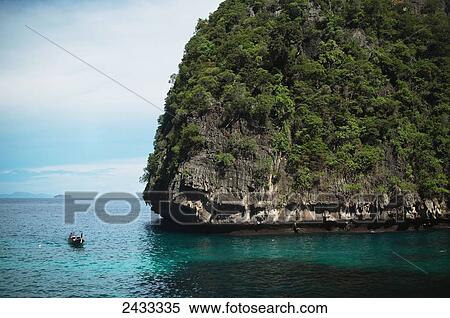 A boat enters a protected bay on the island of Koh Phi Phi in the Andaman Sea; Thailand View Large Photo Image Stock Photography - A boat enters a protected bay on the island of Koh Phi Phi in the Andaman Sea; Thailand. Fotosearch