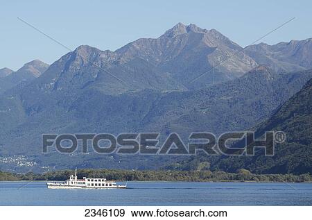 Stock Photo - A Boat In Lake Maggiore With The Swiss Alps In The Background; Locarno, Ticino, Switzerland. Fotosearch