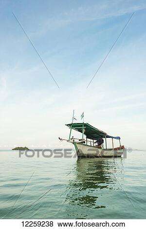 Stock Photo - A boat in the tranquil water off Tui Beach, Koh Rong Island; Sihanoukville, Cambodia Cambodia. Fotosearch