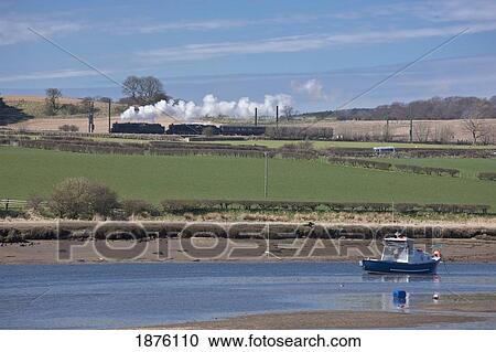 A Boat Moored In The Shallow Water As A Train Crosses The Landscape; Northumberland, England View Large Photo Image Stock Image - A Boat Moored In The Shallow Water As A Train Crosses The Landscape; Northumberland, England. Fotosearch