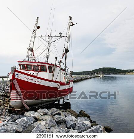 A boat on a lift on the rocky shore at the water's edge; Norris Point, Newfoundland and Labrador, Canada View Large Photo Image Stock Image - A boat on a lift on the rocky shore at the water's edge; Norris Point, Newfoundland and Labrador, Canada. Fotosearch