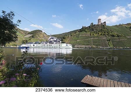 Stock Photograph - A boat on Moselle river with vineyards on the slopes; Mosel, Germany. Fotosearch