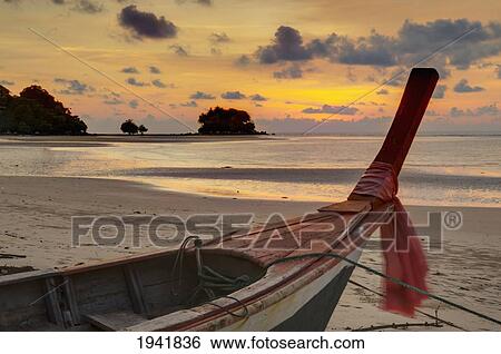 Stock Photograph - A Boat On Nai Yang Beach At Sunset; Phuket Thailand. Fotosearch