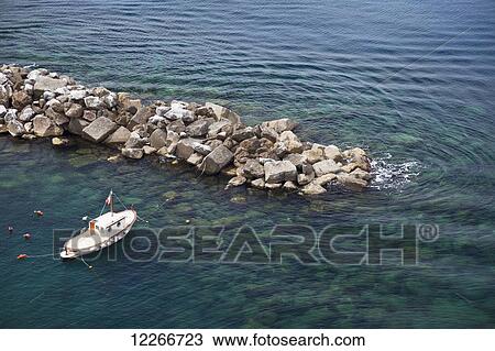 A boat rests in the clear ocean; Riomaggiore, Liguria, Italy View Large Photo Image Stock Image - A boat rests in the clear ocean; Riomaggiore, Liguria, Italy. Fotosearch