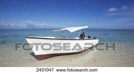 A boat sits in the shallow water on the coast of an island in the Indian Ocean; Mauritius View Large Photo Image Stock Photo - A boat sits in the shallow water on the coast of an island in the Indian Ocean; Mauritius. Fotosearch