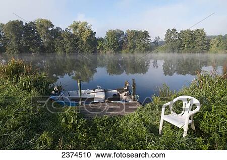 A boat tied to a dock with mist over the lake; Ardennes, Belgium View Large Photo Image Stock Image - A boat tied to a dock with mist over the lake; Ardennes, Belgium. Fotosearch
