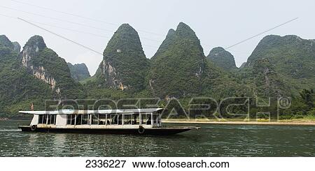 Stock Photo - A Boat Traveling Down Li River; Guilin, Guangxi, China. Fotosearch