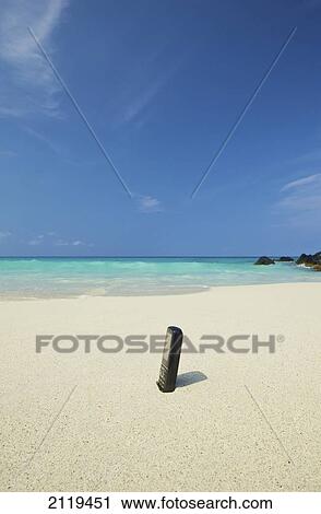 A bottle of sunscreen stuck in the sand on a beach; Wailua, Hawaii, United States of America View Large Photo Image Stock Image - A bottle of sunscreen stuck in the sand on a beach; Wailua, Hawaii, United States of America. Fotosearch