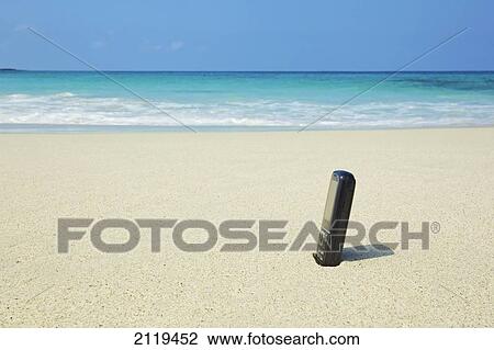 A bottle of sunscreen stuck in the sand on a beach; Wailua, Hawaii, United States of America View Large Photo Image Stock Image - A bottle of sunscreen stuck in the sand on a beach; Wailua, Hawaii, United States of America. Fotosearch