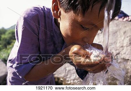 Stock Image - A Boy Drinking Water From A Well. Fotosearch