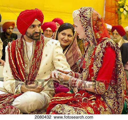 A Bride And Groom Exchanging Rings In An Indian Wedding Ceremony; Ludhiana, Punjab, India View Large Photo Image Stock Image - A Bride And Groom Exchanging Rings In An Indian Wedding Ceremony; Ludhiana, Punjab, India. Fotosearch