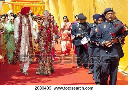 A Bride And Groom Walk Hand In Hand After Their Indian Wedding Ceremony; Ludhiana, Punjab, India View Large Photo Image Stock Image - A Bride And Groom Walk Hand In Hand After Their Indian Wedding Ceremony; Ludhiana, Punjab, India. Fotosearch