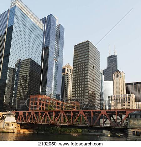 Stock Image - A Bridge Across The River With Buildings In The Background Against A Blue Sky; Chicago Illinois United States Of America. Fotosearch
