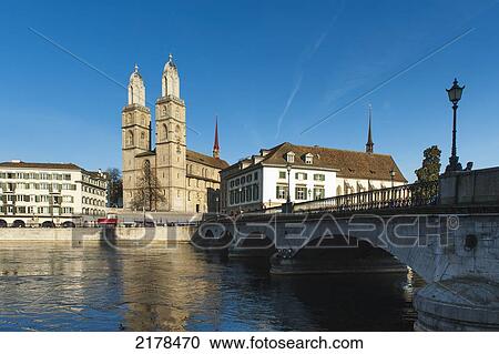 Stock Image - A Bridge Crossing The Water And Buildings At The Water's Edge; Zurich Switzerland. Fotosearch