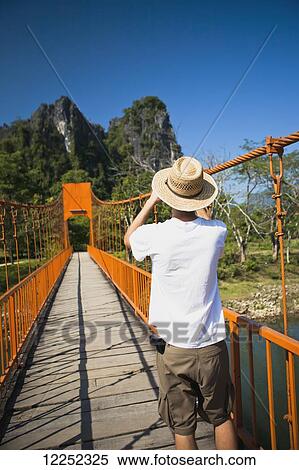 A bridge leads to caves outside of Vang Vieng; Laos View Large Photo Image Stock Photography - A bridge leads to caves outside of Vang Vieng; Laos. Fotosearch