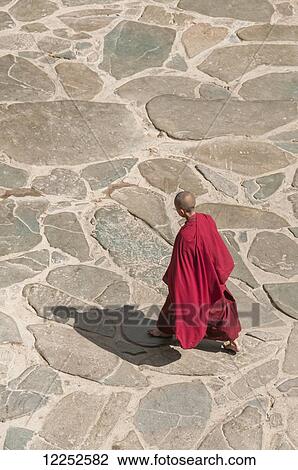 Stock Image - A buddhist monk walks in a temple of Panchen Lama. Fotosearch