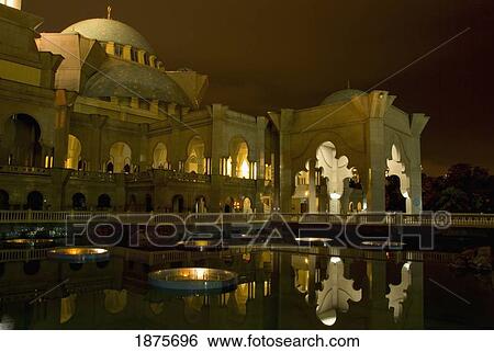 Stock Photograph - A Building By The Water Illuminated At Night; Kuala Lumpur, Malaysia. Fotosearch