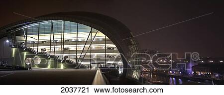 Stock Image - A Building Illuminated At Night Along The River Tyne With A View Of Tyne Bridge In The Background; Gateshead Tyne And Wear England. Fotosearch