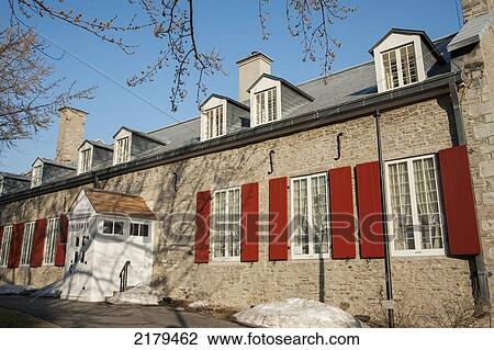 Stock Image - A Building With Red Shutters On The Windows; Montreal Quebec Canada. Fotosearch