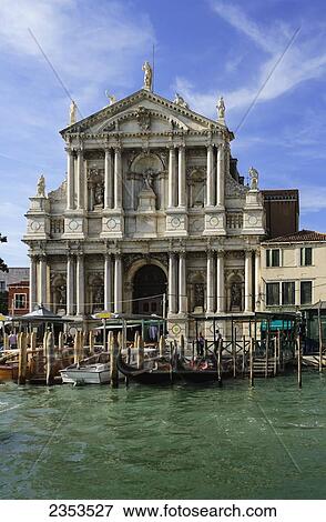 Stock Photo - A Building With Sculptures Along The Roofline And Boats Mooring Along The Grand Canal; Venice, Italy. Fotosearch