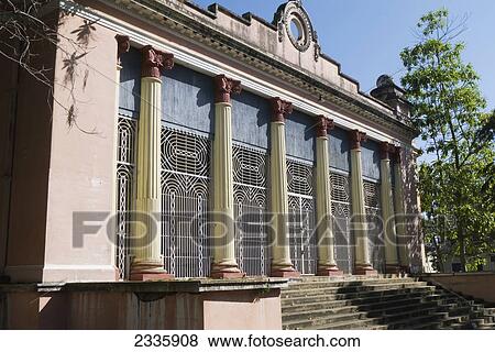 Stock Photo - A Building With Steps And Columns Along The Front And A Blue Sky. Fotosearch