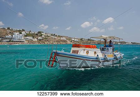 Stock Photo - A caiq or small wooden boat used to ferry tourists to beaches including Paradise and Super Paradise; Mykonos, Cyclades, Greek Islands, Greece. Fotosearch