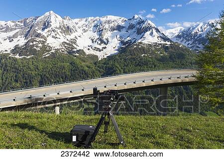 A Camera And Tripod Set On A Grassy Hill To Capture The Snowy Mountain Range; San Gottardo, Ticino, Switzerland View Large Photo Image Stock Image - A Camera And Tripod Set On A Grassy Hill To Capture The Snowy Mountain Range; San Gottardo, Ticino, Switzerland. Fotosearch