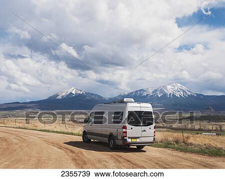 Stock Photo - A Camper Parked On A Gravel Road Just East Of Walsenburg, Colorado With Snow Covered East And West Spanish Peaks In The Background; Walsenburg, Colorado, United States Of America. Fotosearch