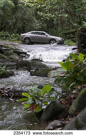 A car driving through a shallow stream on the North Shore at Ha'ena Beach Park; Kauai, Hawaii, United States of America View Large Photo Image Stock Image - A car driving through a shallow stream on the North Shore at Ha'ena Beach Park; Kauai, Hawaii, United States of America. Fotosearch