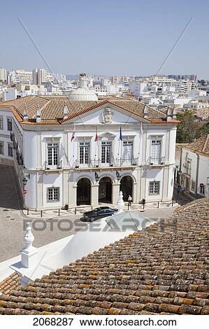 Stock Photo - A Car Parked In Front Of A White Building With The City In The Background; Faro Algarve Portugal. Fotosearch