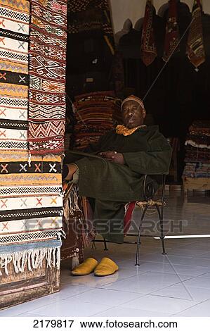 Stock Photo - A carpet seller puts his feet up in his stall in the souks; Marrakesh, Morocco. Fotosearch