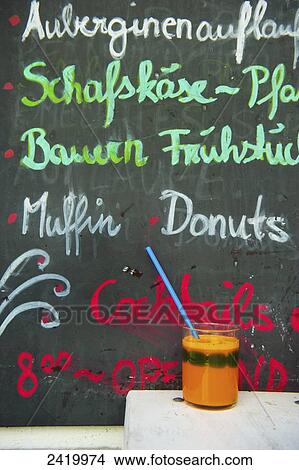 Picture - A chalkboard sign advertising food at a restaurant and a beverage sitting on a table; Hamburg, Germany. Fotosearch