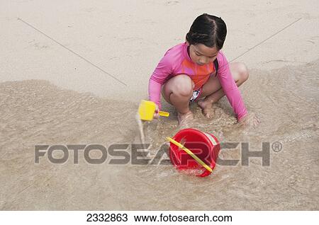 A Child Plays With A Pail And Shovel On The Beach At The Water's Edge, Waikiki, Oahu, Hawaii, United States Of America View Large Photo Image Stock Image - A Child Plays With A Pail And Shovel On The Beach At The Water's Edge, Waikiki, Oahu, Hawaii, United States Of America. Fotosearch
