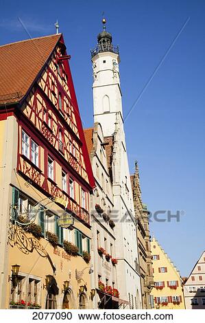 Stock Image - A Church Building And Building With A Peaked Roof Against A Blue Sky; Rothenburg Ob Der Tauber Bavaria Germany. Fotosearch