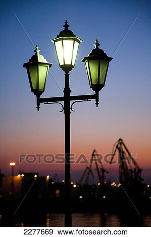 A classical style street lamp and the cargo cranes of Odessa port at sunset; Odessa, Ukraine View Large Photo Image Stock Photo - A classical style street lamp and the cargo cranes of Odessa port at sunset; Odessa, Ukraine. Fotosearch