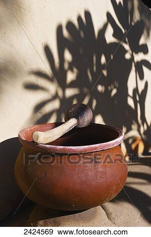 Stock Photo - A clay bowl and wooden tool; Ulpotha, Embogama, Sri Lanka. Fotosearch