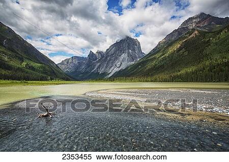 Stock Photography - A Clear Stream Flows Into Glacier Lake In Front Of Mount Harrison Smith; Northwest Territories, Canada. Fotosearch