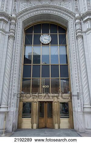 Stock Photo - A Clock Hanging Over The Entrance To A Building; Chicago Illinois United States Of America. Fotosearch