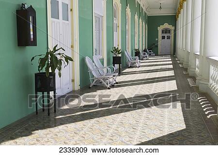 Stock Photo - A Corridor Of Green Walls With White Columns And Doors. Fotosearch