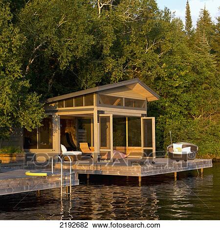 Stock Image - A Cottage With Wooden Dock On The Water's Edge; Lake Of The Woods Ontario Canada. Fotosearch