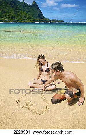 A couple drawing a heart in the sand at the water's edge; Wailua, Hawaii, United States of America View Large Photo Image Stock Image - A couple drawing a heart in the sand at the water's edge; Wailua, Hawaii, United States of America. Fotosearch