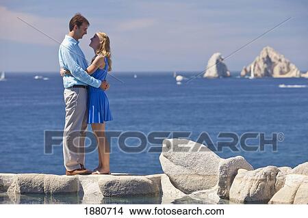 Picture - A Couple In An Embrace Standing At The Water's Edge; Cabo San Lucas; Baja California, Mexico. Fotosearch