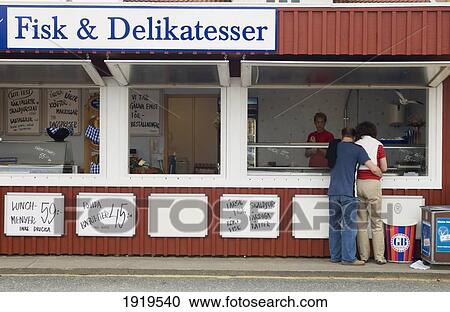 Stock Image - A Couple Outside A Food Stall In The Fishing Village Of Bovallstrand, Bohuslan, Sweden. Fotosearch