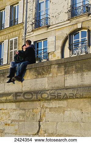 A couple sit kissing on a wall; Paris, France View Large Photo Image Picture - A couple sit kissing on a wall; Paris, France. Fotosearch