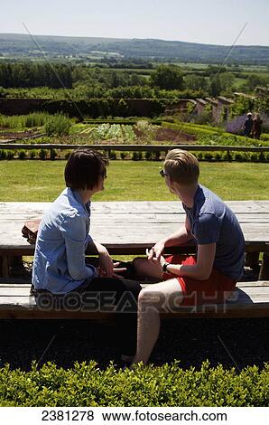 Stock Photo - A couple sits enjoying the view of Barley Wood Walled Garden; Wrington, England. Fotosearch