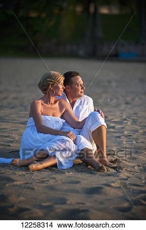A couple sitting on the beach at the Empire Hotel and Country Club; Bandar Seri Begawan, Brunei View Large Photo Image Picture - A couple sitting on the beach at the Empire Hotel and Country Club; Bandar Seri Begawan, Brunei. Fotosearch