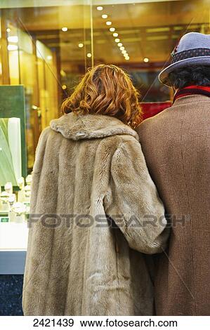 Stock Photo - A couple standing and looking in a jewelry store window, Spitalfields; London, England. Fotosearch