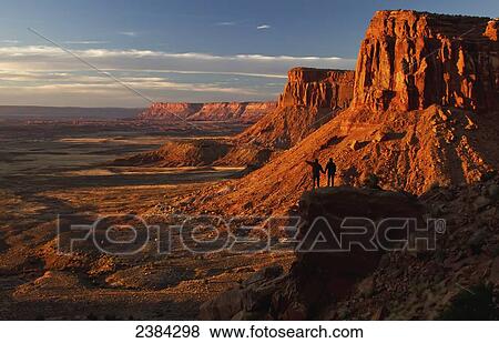 A couple stands holding hands on a ridge overlooking the sandstone landscape; Indian Creek, Utah, United States of America View Large Photo Image Stock Photo - A couple stands holding hands on a ridge overlooking the sandstone landscape; Indian Creek, Utah, United States of America. Fotosearch