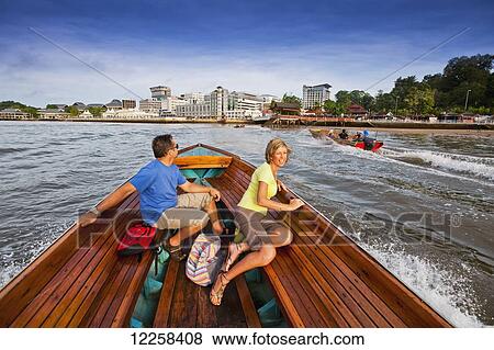 Stock Photo - A couple taking a river boat ride; Bandar Seri Begawan, Brunei. Fotosearch